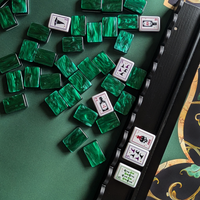 Green mahjong tiles on The Witch's Mat beside a black rack with a scalloped edge